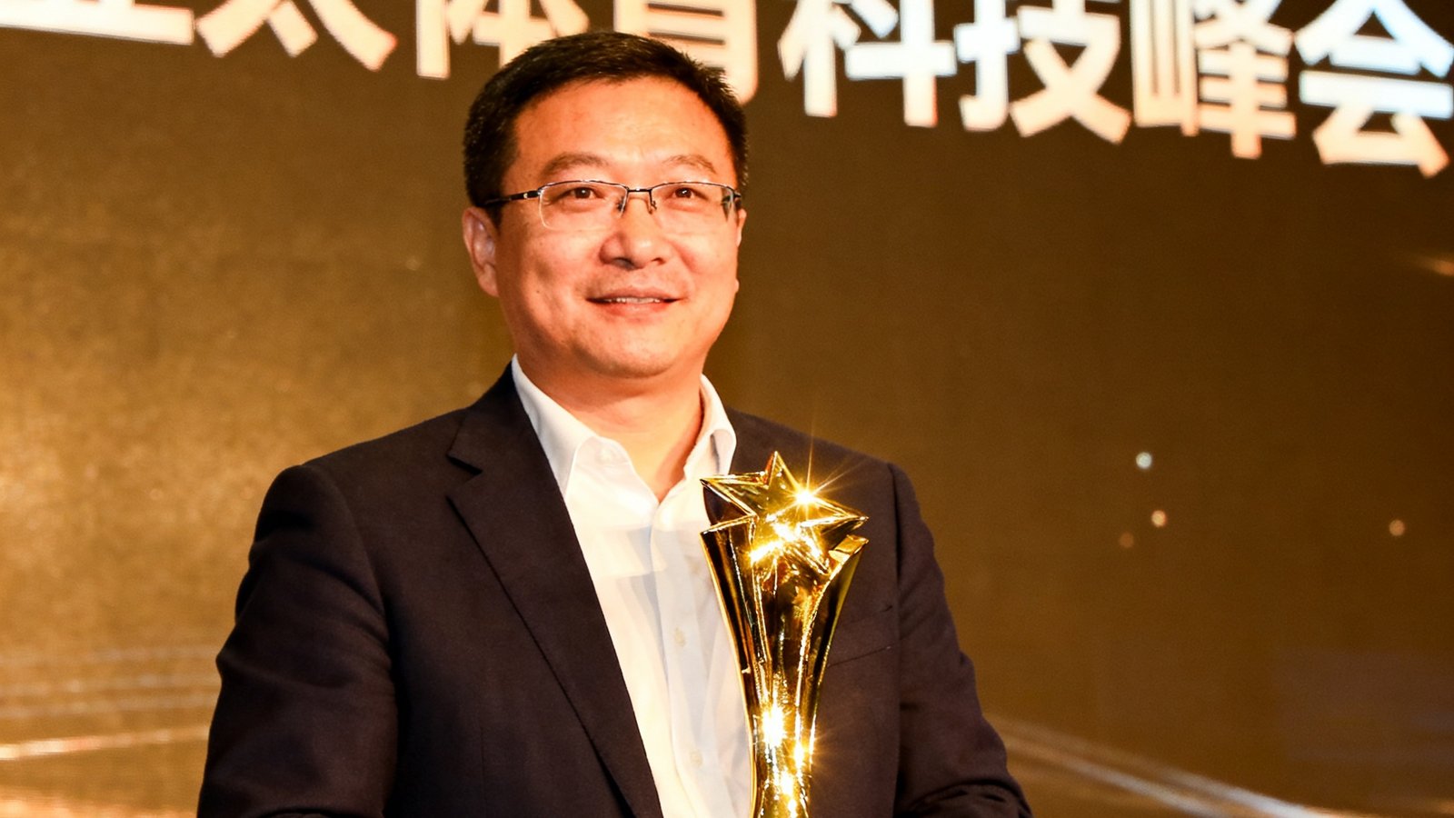 亚太体育科技峰会颁奖典礼，MKSports代表上台领取年度体育科技企业大奖，奖杯在灯光下熠熠生辉，背景是峰会主题背景板。